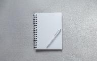 white notebook with pen on top